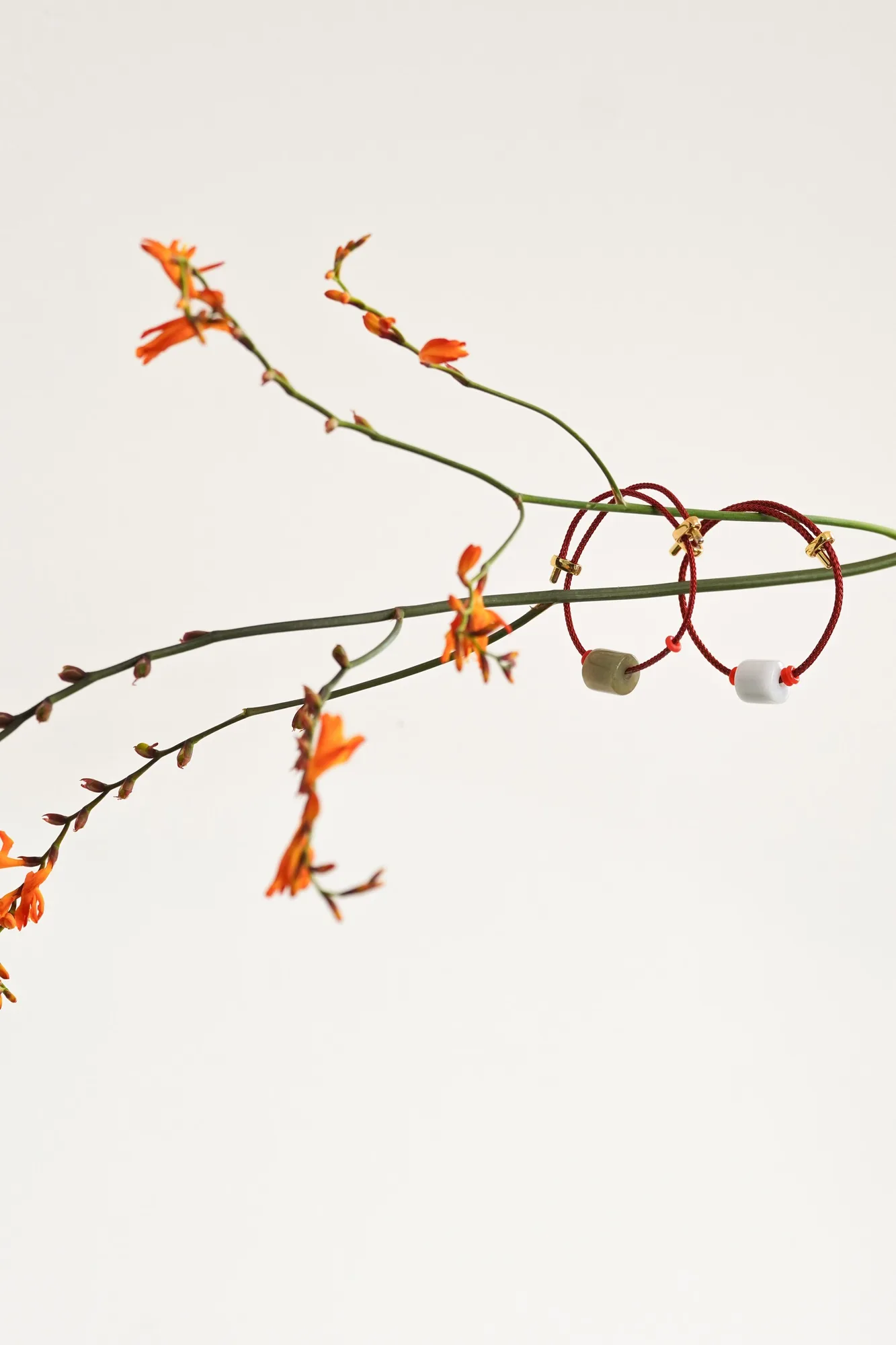 THỨC · Red cord bracelets with flower stems